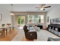 Cozy living room with hardwood floors, a ceiling fan, and sliding glass doors leading to patio at 8132 Stone Path Way, Tampa, FL 33647
