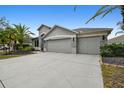 Home featuring a three-car garage, stone accents, and well-maintained landscaping at 8208 Pinewood Run Ct, Tampa, FL 33647
