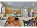 Well-equipped kitchen featuring an island, stainless steel appliances and light wood cabinets at 9023 Sienna Moss Ln, Riverview, FL 33578