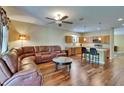 Open-concept living room flows into kitchen, featuring a comfortable leather sofa at 9023 Sienna Moss Ln, Riverview, FL 33578