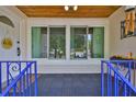 Inviting front porch featuring a tiled floor and covered area, with windows overlooking the yard at 913 Chester Dr, Clearwater, FL 33756