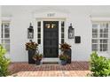 Elegant front door with brick patio, enhanced by flanking planters and stylish lighting at 1207 S Druid Ln, Tampa, FL 33629