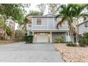 Charming two-story home featuring a spacious driveway and a well-maintained landscaped yard with a palm tree at 138 69Th N Ave, St Petersburg, FL 33702
