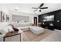 Inviting living room boasts an oversized sectional couch, modern ceiling fan, and a sleek black accent wall at 14 S Meteor Ave, Clearwater, FL 33765