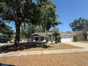 Single-story home with mature landscaping, a two-car garage, and a walkway leading to the front door at 1710 Tallowtree Cir, Valrico, FL 33594