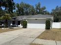 Single-story home featuring a two-car garage, well-maintained lawn, and established shrubbery at 1710 Tallowtree Cir, Valrico, FL 33594