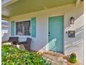 Charming home entrance featuring a vibrant teal door, brick pavers, and inviting décor at 1727 New Hampshire Ne Ave, St Petersburg, FL 33703