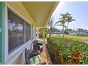 Cozy porch with comfortable seating, vibrant flowers, and a view of the lush greenery and street beyond at 1727 New Hampshire Ne Ave, St Petersburg, FL 33703