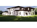 Rear of modern house featuring ample windows and a well-manicured lawn, ideal for relaxation and entertainment at 19207 Gunn Hwy, Odessa, FL 33556