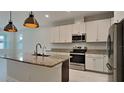 The kitchen boasts granite countertops, modern stainless appliances, an island sink, and updated lighting at 20092 Stone Pine Cir, Lutz, FL 33558