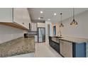 This spacious kitchen offers granite counters, stainless appliances, and island sink with modern pendant lighting at 20092 Stone Pine Cir, Lutz, FL 33558