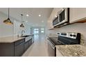 Modern kitchen design with stainless appliances, island sink, and granite countertops at 20092 Stone Pine Cir, Lutz, FL 33558