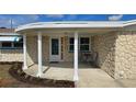Inviting covered front porch with stylish support columns and outdoor seating area at 2035 Erin Dr, Holiday, FL 34690