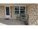 Close up of the entry door and an outdoor seating area on the covered front porch at 2035 Erin Dr, Holiday, FL 34690