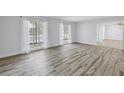 Bright, open living room featuring wood-look floors and large windows with sheer curtains at 2146 Egret Drive, Clearwater, FL 33764