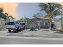 Inviting house with a well-maintained yard, mature palms, and a decorative stone facade at 265 115Th Ave, Treasure Island, FL 33706