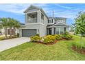 Charming two-story home with a balcony, a well-manicured lawn, and vibrant landscaping at 2693 Leafwing Ct, Palm Harbor, FL 34683