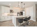 Modern kitchen featuring white cabinets, quartz countertops, stainless steel appliances, and a breakfast bar at 2693 Leafwing Ct, Palm Harbor, FL 34683