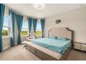 Bright and airy main bedroom with large windows, neutral decor, and a sitting area at 2693 Leafwing Ct, Palm Harbor, FL 34683