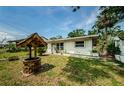 Quaint single-story home featuring a well maintained lawn, a decorative wishing well, and partial fencing at 306 Banana St, Tarpon Springs, FL 34689
