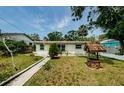 Inviting single-story home with a well-manicured lawn and a charming wishing well in the front yard at 306 Banana St, Tarpon Springs, FL 34689