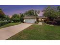 A suburban home at dusk features lush landscaping and a freshly painted two-car garage at 3268 Tanglewood Trl, Palm Harbor, FL 34685