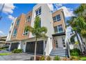 Modern multi-level home with wood and white accents, a private garage, and beautifully landscaped entry at 344 Capri Blvd, Treasure Island, FL 33706
