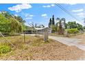 Exterior view of a home with mature trees and a chain-link fence at 3614 Fortner Rd, Plant City, FL 33567