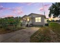 Exterior view of cozy home with charming porch and fresh landscaping; the scene is beautifully lit by the sunset at 3801 Carroway St, Tampa, FL 33619