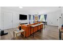 Bright living room featuring an orange sofa, a flat screen tv, hardwood floors, and lots of natural light at 3801 Carroway St, Tampa, FL 33619