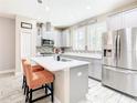 Modern kitchen with stainless steel appliances, gray cabinets, quartz countertops and a center island with seating at 5807 Circa Fishhawk Blvd, Lithia, FL 33547