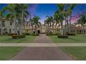 Elegant Mediterranean style home with a long driveway lined with palm trees and manicured landscaping at 624 Balibay Rd, Apollo Beach, FL 33572