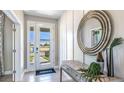 Bright foyer featuring tiled floor, decorative mirror, table and front door letting in lots of natural light at 6745 Flint Creek Dr, Land O Lakes, FL 34638