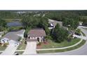 Aerial view of a charming two-story home featuring mature trees, a well-maintained lawn, and a two car garage at 7334 Night Heron Dr, Land O Lakes, FL 34637