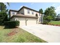 Charming two-story home featuring a well-maintained lawn, mature trees, and a three car garage at 7334 Night Heron Dr, Land O Lakes, FL 34637