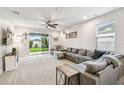 Comfortable living room featuring a large sectional sofa and sliding glass doors to the backyard at 8228 Sunlit Horizon Ln, Land O Lakes, FL 34637