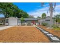 Inviting home with a well-manicured front yard, decorative fence, and a pathway leading to the red front door at 8407 Granite Pl, Tampa, FL 33615