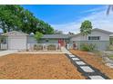 Charming home with a well-manicured front yard, decorative fence, and a pathway leading to the red front door at 8407 Granite Pl, Tampa, FL 33615