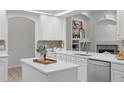 Bright kitchen with white cabinets, island, stainless steel appliances, and designer fixtures at 10232 Estuary Dr, Tampa, FL 33647