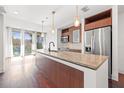Bright, modern kitchen featuring a large island, stainless steel appliances, and wooden cabinetry at 111 N 12Th St # 1305, Tampa, FL 33602