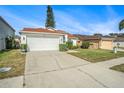 A cozy one-story home with a two car garage and a neatly landscaped yard on a sunny day at 1247 Ocean Reef Rd, Wesley Chapel, FL 33544
