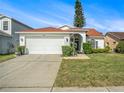 Beautiful one-story home with a two-car garage, lush lawn, and mature landscaping at 1247 Ocean Reef Rd, Wesley Chapel, FL 33544