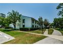 Exterior of well-maintained condo building with lush landscaping, sidewalks, and parking spaces at 1290 Pine Ridge E Cir # G1, Tarpon Springs, FL 34688