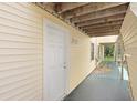 Condo entryway featuring a white door and yellow siding at 134 Sycamore Ln # F, Oldsmar, FL 34677