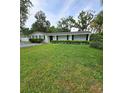 Well-manicured front yard with lush green grass and neatly trimmed hedges, enhancing curb appeal at 1412 Sunset Ln, Lutz, FL 33549