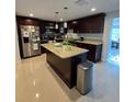 Modern kitchen features an island, granite countertops, stainless steel appliances, and ample cabinet space at 1412 Sunset Ln, Lutz, FL 33549