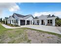 Charming home featuring an attached two-car garage, side porch, and meticulously maintained landscaping at 14902 Sweat Loop Rd, Wimauma, FL 33598