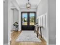 Welcoming foyer features a stylish rug, wood floors, and a view of the outdoors through double doors at 14902 Sweat Loop Rd, Wimauma, FL 33598