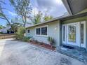 Welcoming front entrance with a decorative glass door, beautiful landscaping, and a stone walkway at 232 Pinecrest Dr, Palm Harbor, FL 34683