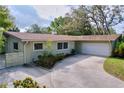 Charming single-story home featuring an attached garage, lovely landscaping, and inviting curb appeal at 232 Pinecrest Dr, Palm Harbor, FL 34683